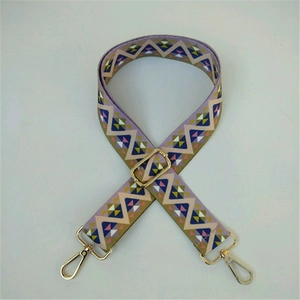 Detail of adjustable ethnic style bag strap with purple geometric patterns and gold metal hooks