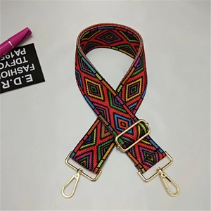 Close-up of geometric ethnic woven wide shoulder strap with gold metal hooks and buckle