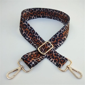 Close-up of leopard print bag strap with adjustable gold buckle and lobster clasps