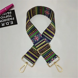 Close-up of adjustable wide woven shoulder strap with geometric patterns and gold clips