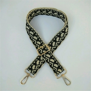 Close-up of retro geometric pattern wide bag strap with golden metal swivel hooks