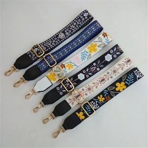 Close-up of adjustable embroidered bag straps with colorful patterns and gold metal buckles