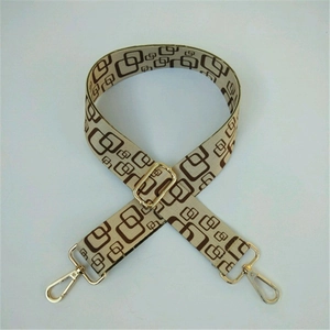 Adjustable woven handbag strap with brown geometric patterns and gold metal hooks