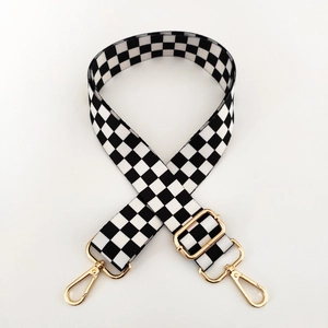 Detail of wide black and white checkerboard canvas strap with adjustable gold buckle
