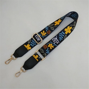 Detail of adjustable bohemian floral patterned strap with gold lobster clasps and black leather