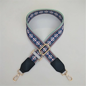 Adjustable geometric ethnic pattern bag strap with leather trim and gold metal hardware