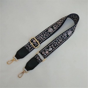 Close-up of ethnic jacquard strap with floral pattern and golden metal swivel hooks