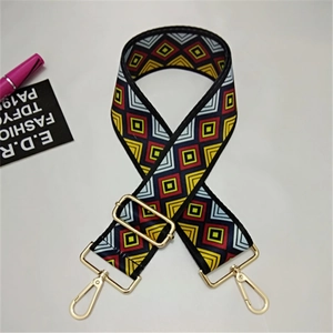 Detailed view of wide ethnic geometric shoulder strap with gold metal lobster clasps