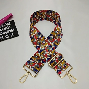 Detail of adjustable wide canvas shoulder strap with colorful geometric patterns and gold metal clips