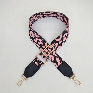 Close-up of pink leopard canvas bag strap with golden metal swivel hooks and buckles