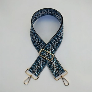 Close-up of blue and white geometric jacquard bag strap with gold metal lobster clasps