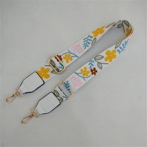 Detail of adjustable floral replacement bag strap with white leather and gold hooks