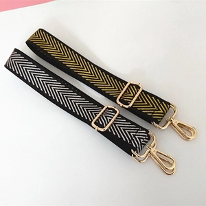 Macro detail of adjustable woven nylon bag straps with classic herringbone patterns