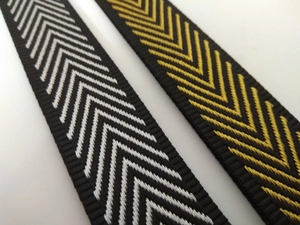 Close-up of adjustable nylon bag straps with black-white and black-gold herringbone patterns
