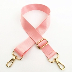 Close-up of pink nylon shoulder strap with adjustable golden metal buckles and hooks