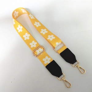 Detail of yellow floral bag strap with gold metal lobster clasps and buckle