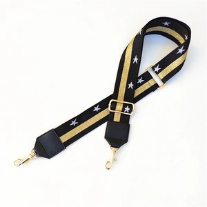 Macro detail of black woven strap with gold glitter stripes and white star embroidery