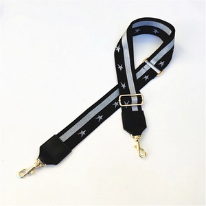Detail of adjustable star pattern woven shoulder strap with gold metal swivel hooks
