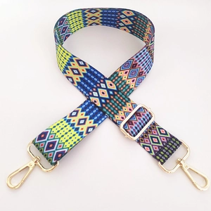 Close-up of geometric woven shoulder strap with gold metal lobster clasps and buckles