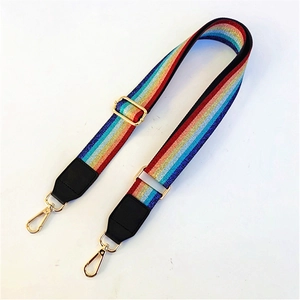 Detail of adjustable woven shoulder strap with rainbow stripes and gold metal hardware