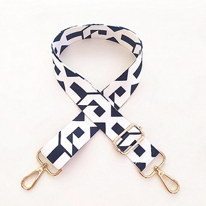 Detailed view of black and white geometric pattern strap with golden metal lobster clasps