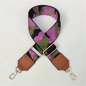 Macro detail of adjustable pink camo pattern shoulder strap with gold metal hooks