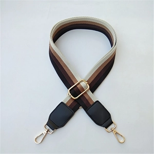 Adjustable striped canvas bag strap with gold metal hooks and black leather details