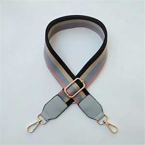 Close-up of adjustable striped fabric bag strap with PU leather ends and gold metal hooks