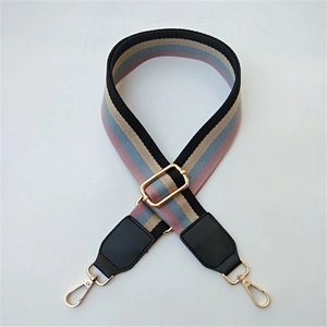 Detail of adjustable ethnic style wide canvas strap with golden metal swivel hooks