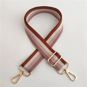 Close-up of multicolor striped canvas bag strap with golden metal lobster clasps
