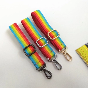 Detailed view of three adjustable rainbow striped nylon bag straps with varied metal buckles
