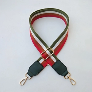 Close-up of ethnic style wide adjustable bag strap with striped weave and gold hooks