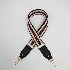 Adjustable striped fabric shoulder strap with black leather ends and gold metal hooks