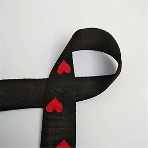 Vue détaillée de la sangle noire avec motifs de cœurs rouges brodés et texture fine