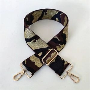 Close-up of metallic camo weave wide bag strap with adjustable gold buckle and lobster clasps