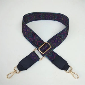 Close-up of ethnic style purple woven strap with geometric patterns and gold metal hooks