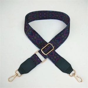 Close-up of ethnic geometric purple and green patterned strap with gold metal hooks