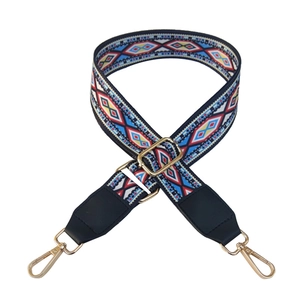 Detail of bohemian woven canvas bag strap with colorful diamond patterns and gold hooks