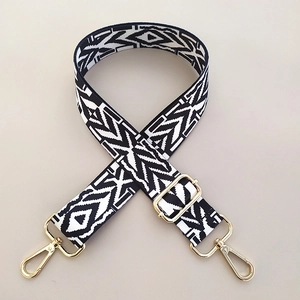 Close-up of black and white geometric ethnic bag strap with gold metal lobster clasps