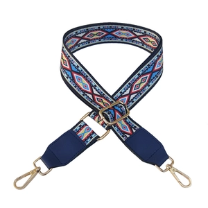 Detail of ethnic geometric embroidered bag strap with gold lobster clasps and buckles