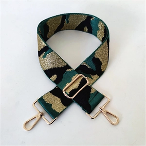 Detail of 5cm wide camouflage jacquard bag strap with gold metal hooks and buckle