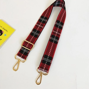 Detail of red and black tartan canvas strap with adjustable gold metal buckle and hooks