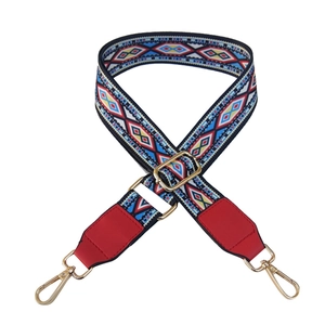 Close-up of ethnic style woven strap with colorful geometric patterns and gold metal hooks