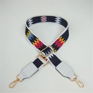Close-up of adjustable woven shoulder strap with ethnic geometric patterns and gold metal clips