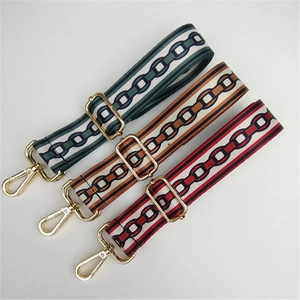 Close-up of three colorful woven bag straps with geometric patterns and gold lobster clasps