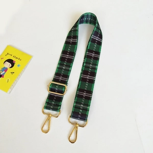 Detail of adjustable thickened canvas shoulder strap with green check and gold hardware