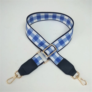 Detail of adjustable blue and white checkered canvas strap with gold swivel hooks
