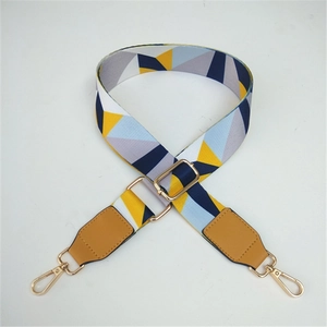 Close-up of geometric color block bag strap with brown leather and gold metal hooks