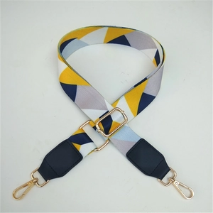 Macro shot of colorful geometric woven bag strap with golden metal lobster clasps