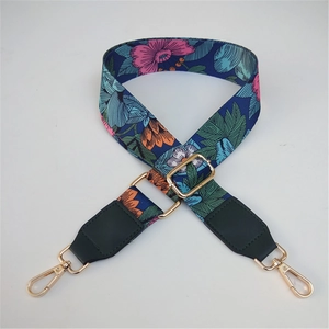 Detail of floral pattern on adjustable nylon bag strap with gold metal buckles